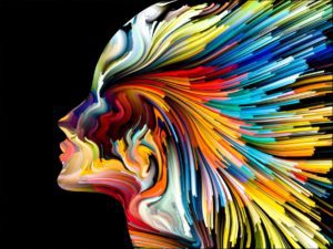 A colorful painting of a woman 's face with feathers on it.