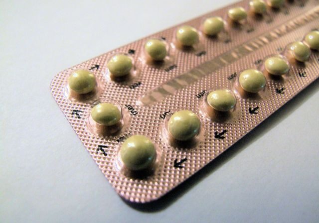 A close up of a pink and white strip of contraceptive pills.