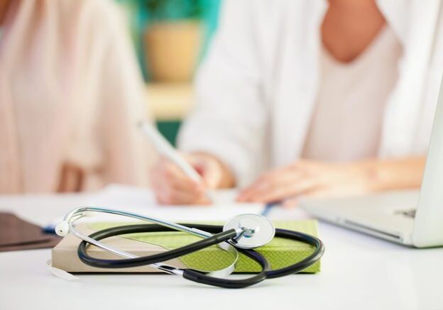 A stethoscope is laying on top of a book.